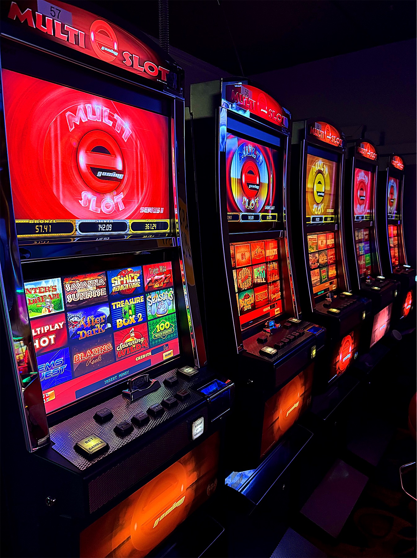 A row of neon-lit slot machines